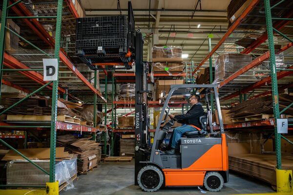 A forklift operator retrieving a pallet from racking