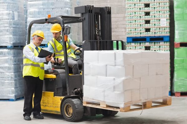 A supervisor confering with a forklift operator