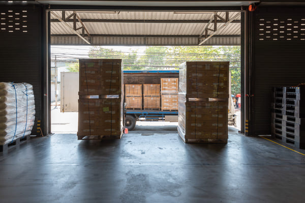 A truck unloading pallets in a receiving dock