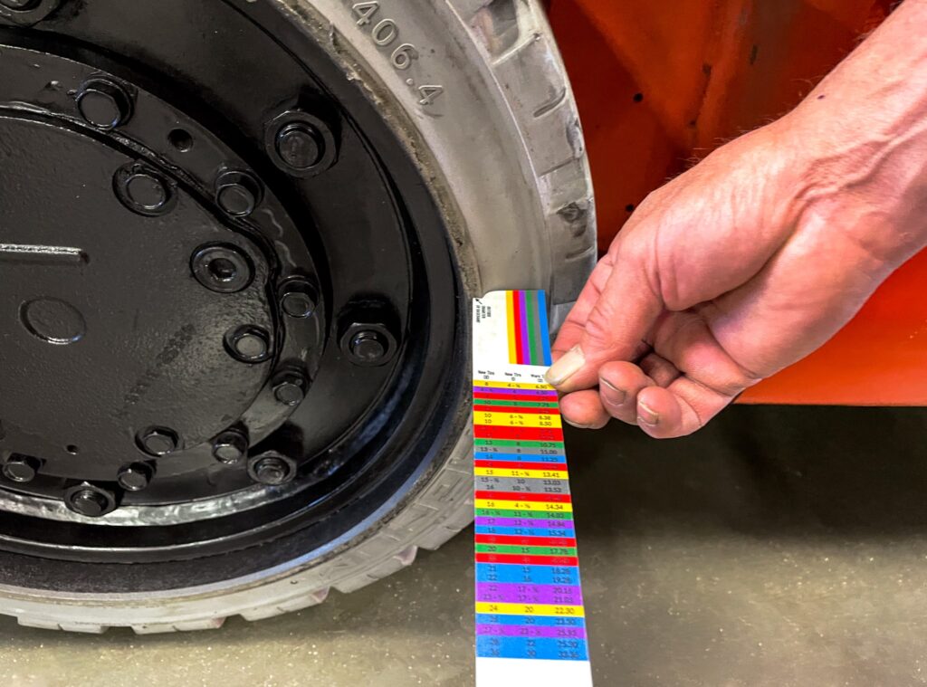 person inspecting forklift tires