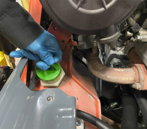 Remove the cap from the forklift hydraulic fluid reservoir